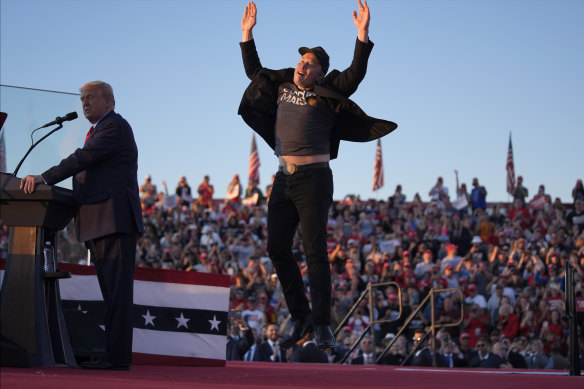 Elon Musk jumps on the stage as Republican presidential nominee Donald Trump speaks at a campaign rally in Butler, Pennsylvania, on October 5.